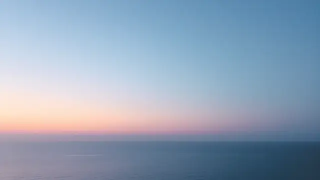 A pastel sky over calm water at dusk