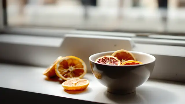 A neutral-tone ceramic bowl with dried citrus slices