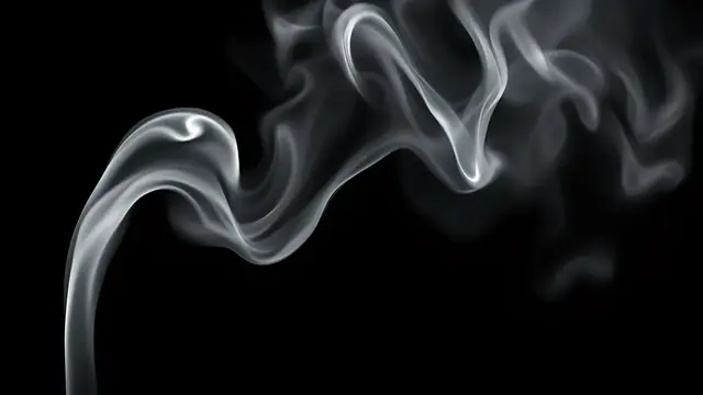 Wisps of white smoke curling against a black background