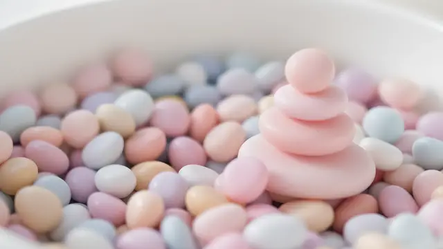 Small round pastel-coloured stones stacked in a bowl