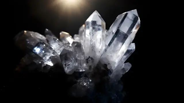 A quartz crystal cluster with dramatic side light on a dark background