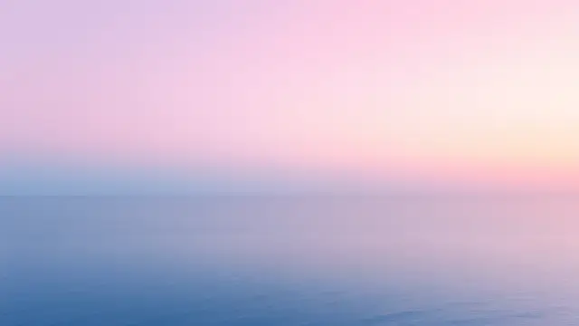 A calm sea horizon at dawn with a pastel sky