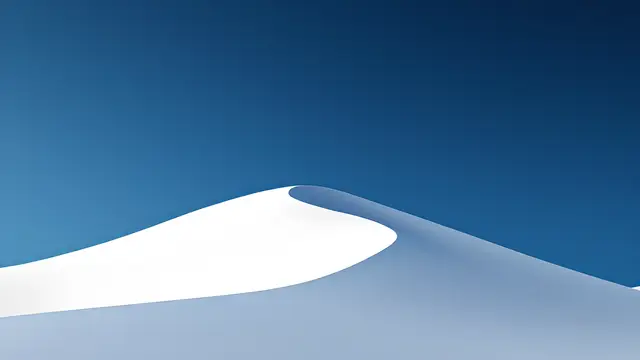 A white sand dune ridge against a deep blue sky