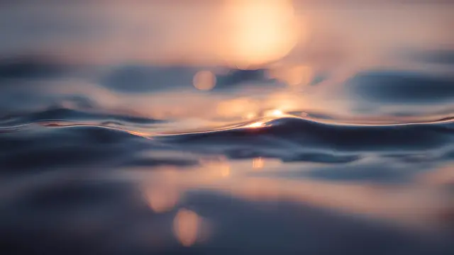 A still water surface reflecting warm light at dusk