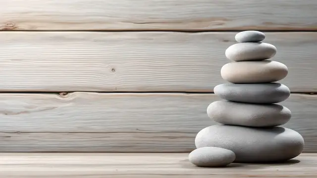 Smooth stones stacked on a wooden surface