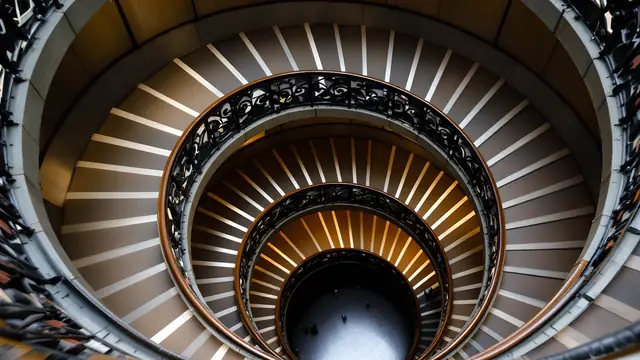 A spiral staircase with an ornate iron railing, seen from above