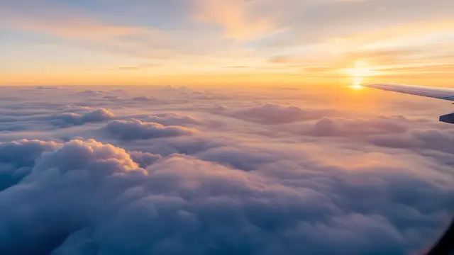 Clouds seen from above an aeroplane window at golden hour
