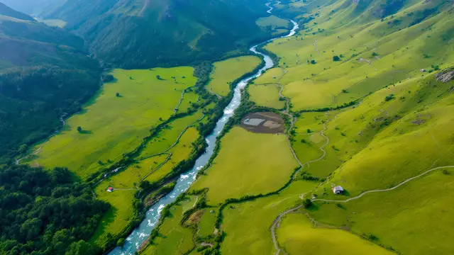 A winding river through a green valley, seen from above
